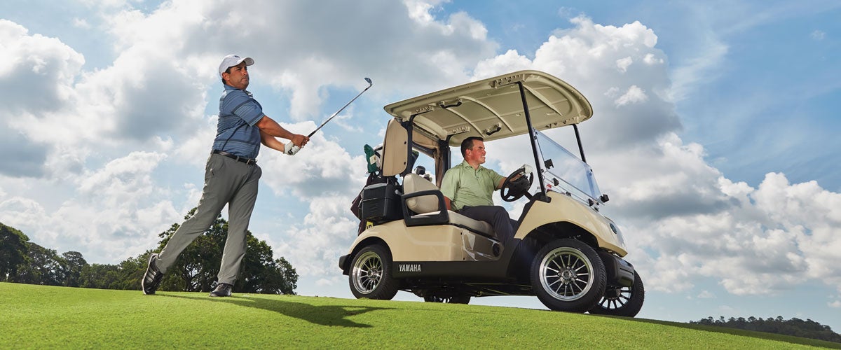 Two men golfing using a Yamaha cart