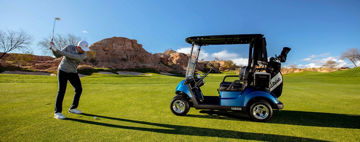 Golfer next to Yamaha cart